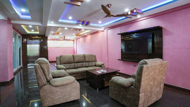 A modern lounge area with plush seating, a flat-screen TV, and ambient lighting. - A White Pearl Suites (Bengaluru)