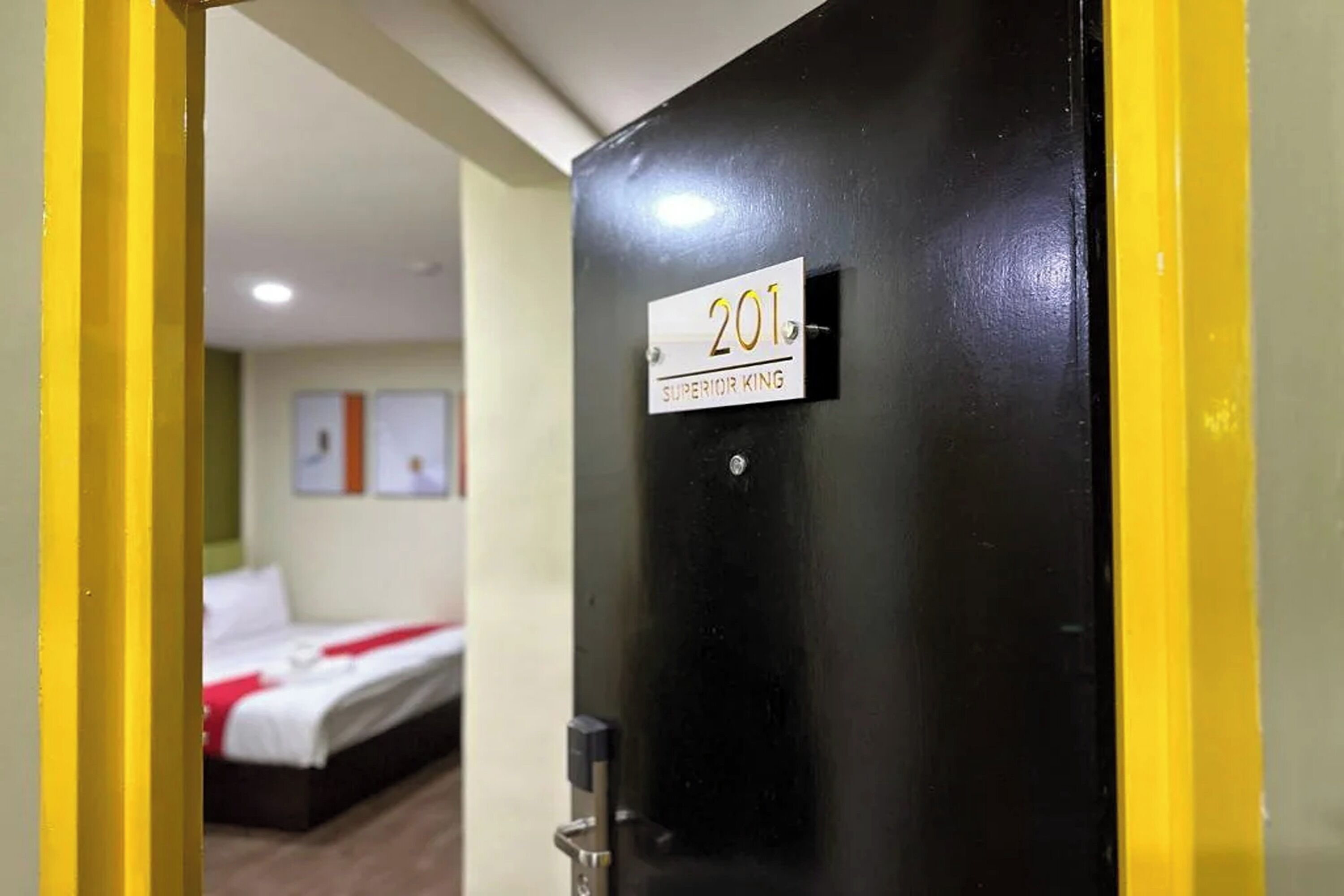 Puerta de una habitación de hotel con un letrero que dice "201 Superior King".