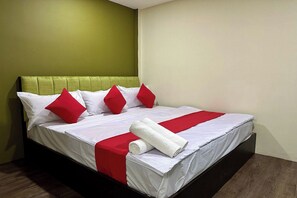 A neatly made bed with white and red bedding, a green headboard, and a rolled white towel. - Hotel MSP Bukit Bintang (Kuala Lumpur)