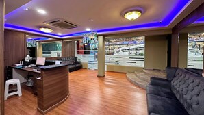A hotel lobby with a reception desk, seating area, and large windows offering a view of the street. - Hotel MSP Bukit Bintang (Kuala Lumpur)