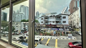 A view of a cityscape through a window, including a building with a sign for 'MEZBAN GRILLS'. - Hotel MSP Bukit Bintang (Kuala Lumpur)