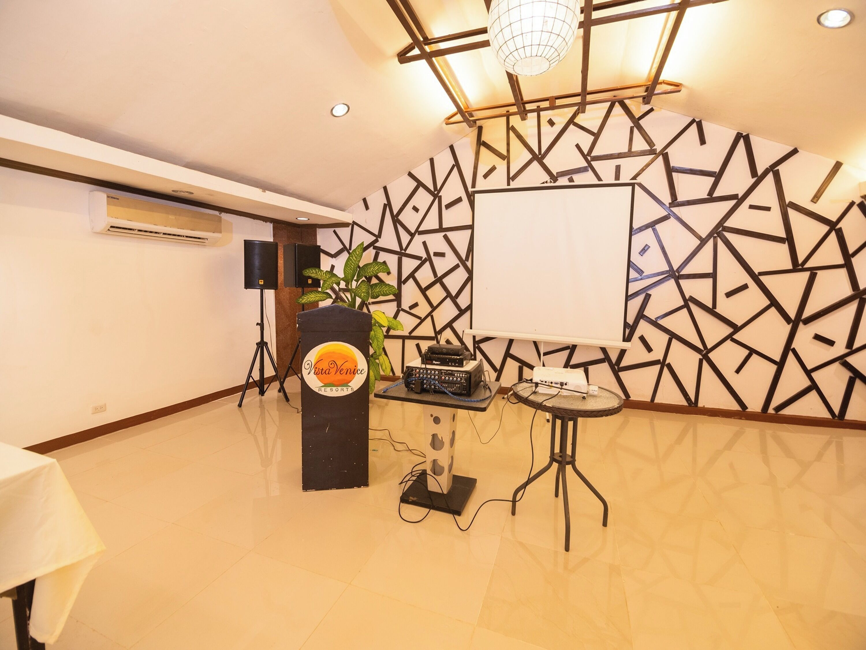 A conference room with a podium, a whiteboard, and a table with audio equipment.