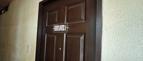 A brown door with a sign that reads "SUNFLOWER 5".