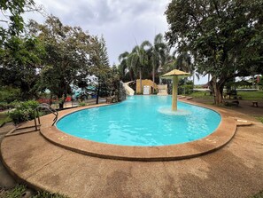 A swimming pool with a stone border, a small pavilion, and a waterfall feature. - Vista Venice Resort (Morong)