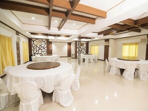 A spacious banquet hall with multiple round tables covered with white tablecloths and chairs. - Vista Venice Resort (Morong)