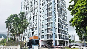 Un immeuble résidentiel à plusieurs étages, doté de balcons et d’une entrée sécurisée par un portail.
