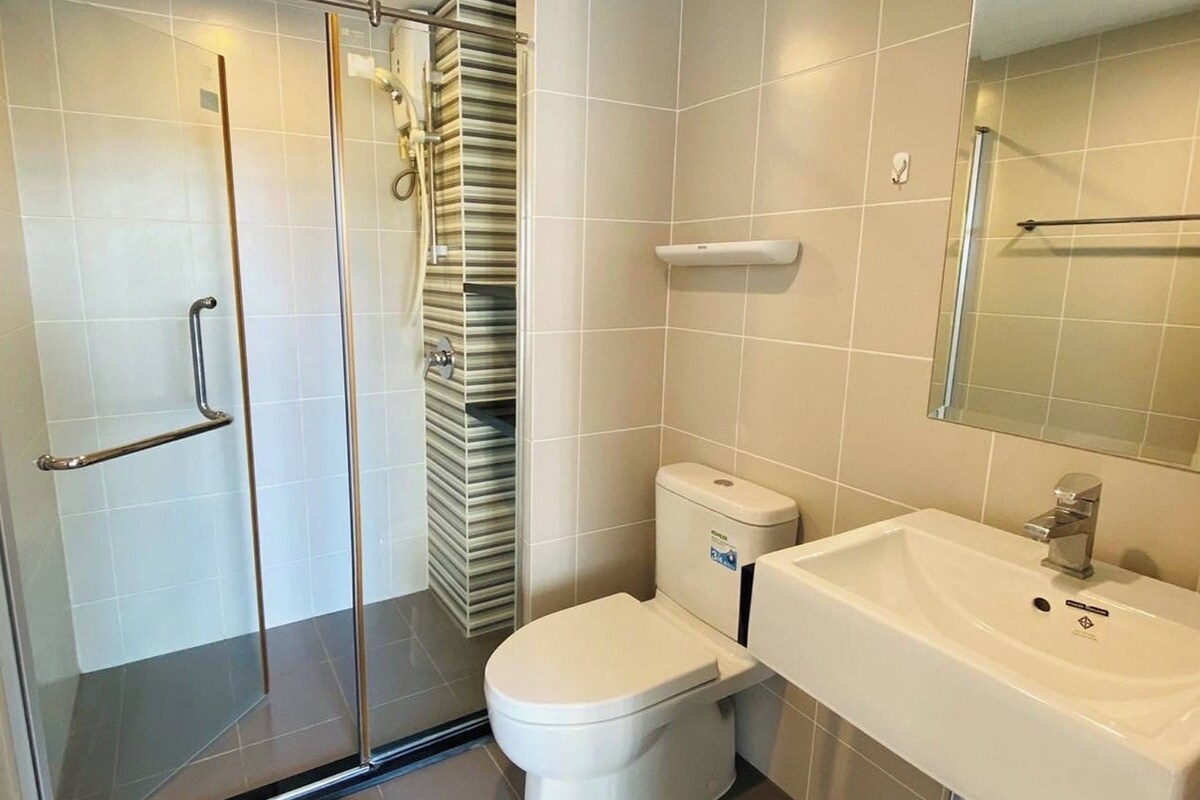 Een moderne badkamer met een douchecabine van glas, een toilet en een wastafel met spiegel erboven.