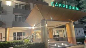 Un edificio de varios pisos con una entrada destacada que dice 'CARPEDIEM'.