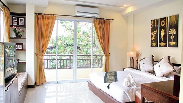 A hotel room with a balcony, a bed with white linens, a TV, and a desk. - Le Viengping Chiangmai (Chiang Mai)