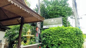 A building with a sign reading "Levienging" and a small shrine with a yellow statue. - Le Viengping Chiangmai (Chiang Mai)