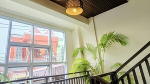 A spacious interior with large windows, a wooden ceiling, and a staircase with a railing. - Le Viengping Chiangmai (Chiang Mai)