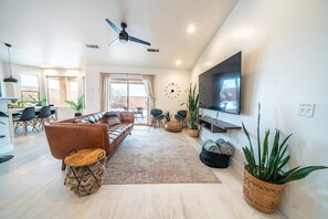 Una sala de estar moderna con sofá, mesa de centro y plantas en macetas.