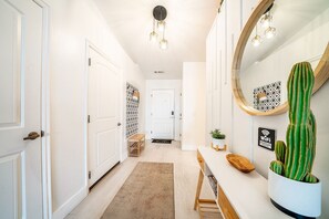 A hallway with white doors, a wooden bench, a cacti planter, and a WiFi sign. - Stonecliff Escape Sum (Page)