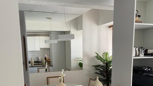 A modern kitchen with white cabinets, a black countertop, and two decorative vases.