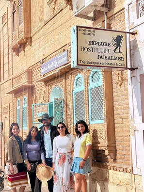 Un hostal con un letrero que anuncia 'Explore Hostlife Jaisalmer - The Backpacker Hostel & Cafe'.