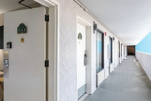 Corredor com portas numeradas 533 e 534, com interfones e placa de proibido fumar.