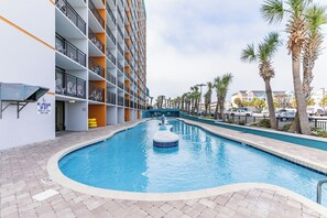 A swimming pool with a blue tile border, surrounded by a brick walkway.