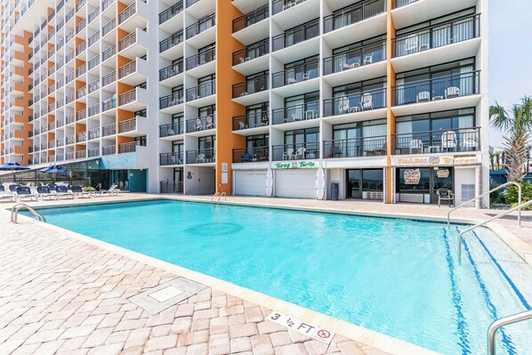 A hotel with a swimming pool, multiple balconies, and a restaurant named "First Terra."