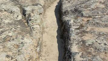 An ancient stone structure with a narrow passageway and a small opening at the end.