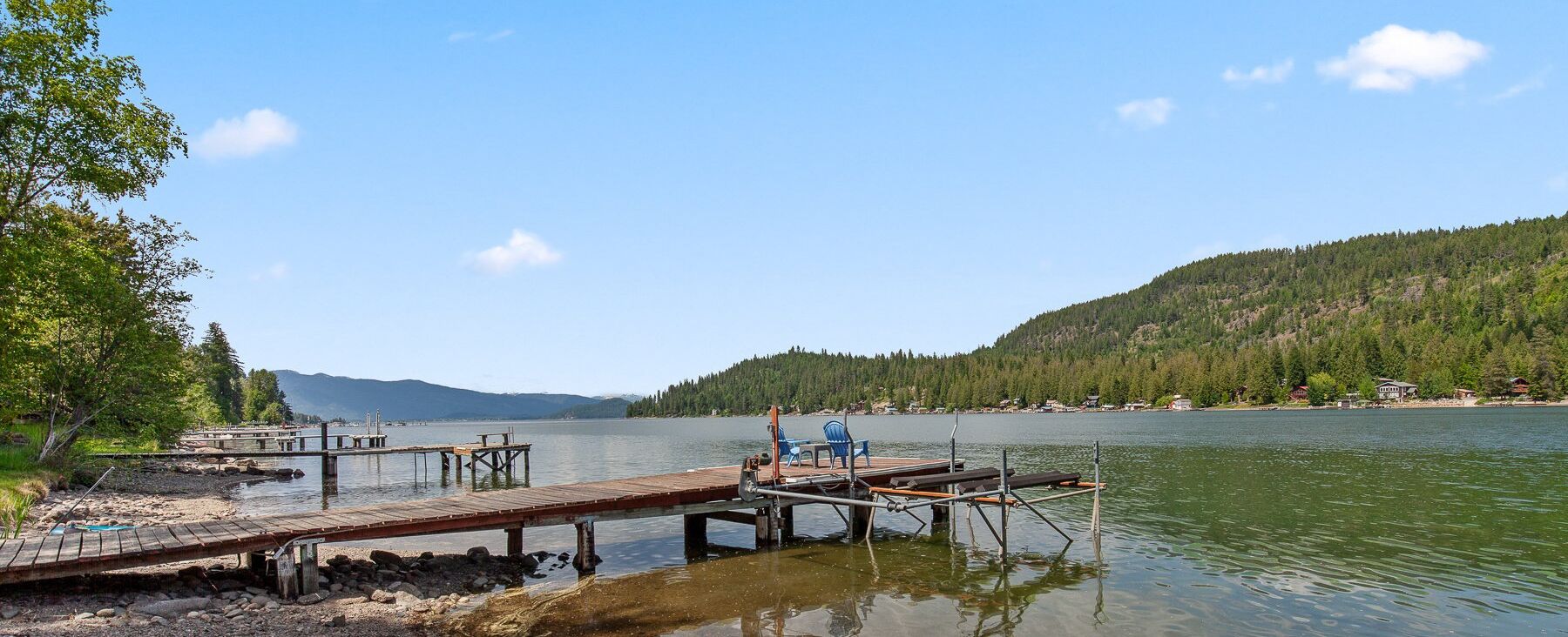 A lakeside dock with wooden walkways and a small dock chair.