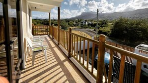 Un balcon donnant sur une route et des montagnes.