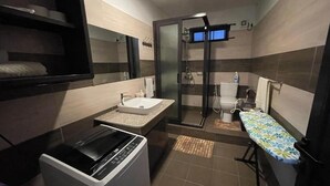 Een kleine badkamer met een wastafel, toilet en douche.