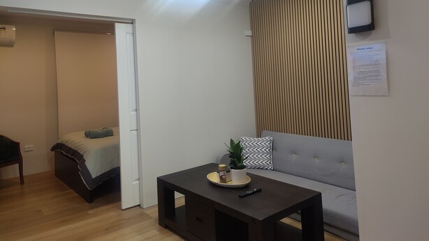 Un salon moderne avec un canapé, une table basse et un luminaire suspendu au plafond.