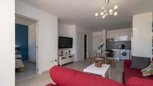 A modern apartment with a living room, dining area, and kitchen. - Andalucia 5 - One Bed (Costa Adeje)