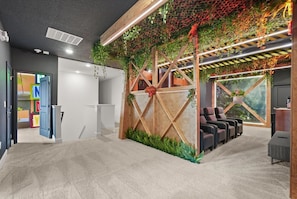 Un espace d’accueil doté d’une cloison en bois, de sièges et d’un mur orné de plantes suspendues.