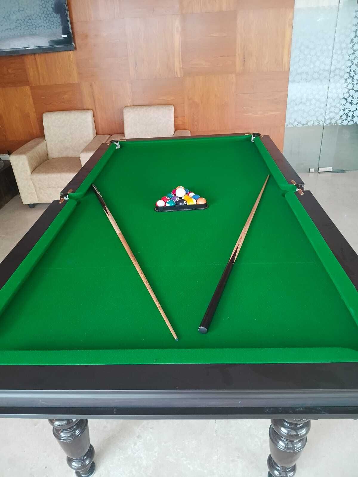 A pool table with two cues and a rack of billiard balls.