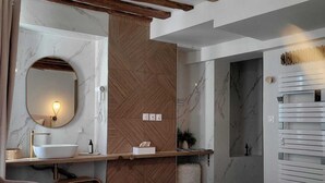 A modern bathroom with a wooden ceiling, a marble sink, and a large mirror. - 4 Charming Suites & downtown (Sens)