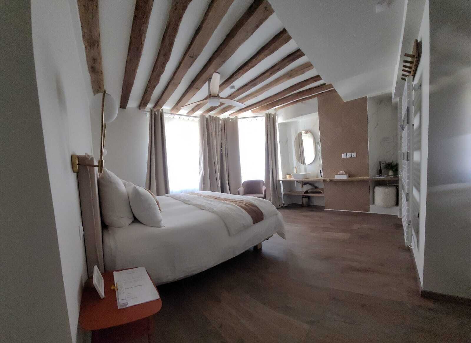 Een slaapkamer met een bed, een bureau, een spiegel en een kledingkast.