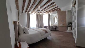 Een slaapkamer met een bed, een bureau, een spiegel en een kledingkast.