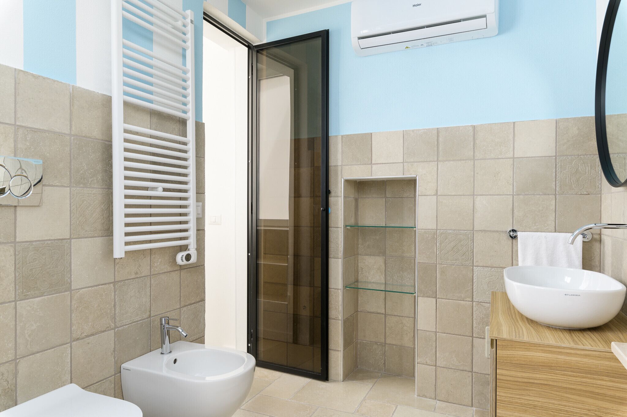 Ein modernes Badezimmer mit Duschkabine aus Glas, einem weißen Waschbecken und einem Bidet.