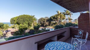 A balcony with a pool, surrounded by greenery and palm trees, overlooking a clear blue sky. - Margiù Capomulini Home by Wonderful Italy (Acireale)