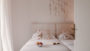 A bedroom with a bed, pillows, a bowl of fruit, and a hanging decoration. - Paradise Overlook - Beachfront Villa (Pefkohori)