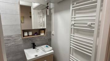 Een douche, handdoeken, zeep, toiletpapier