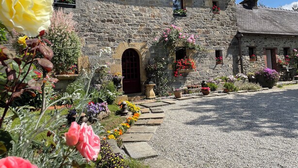 A stone building with a red door, flower boxes, and a gravel driveway. - Auberge de keranden (Landerneau)