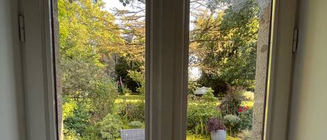 A door with a view of an outdoor patio area with wicker furniture and a gravel ground.
