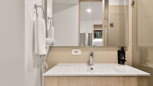 A modern bathroom with a white sink, wooden vanity, a mirror, and a towel rack. - NOK Spectacular Loft in Usaqu n (Bogotá)