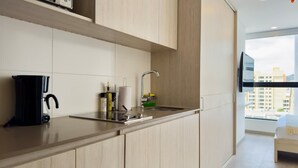 A modern kitchen with a coffee maker, a sink, and a window with a city view. - NOK Spectacular Loft in Usaqu n (Bogotá)
