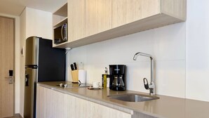 Une cuisine moderne dotée d’un évier en acier inoxydable, d’une machine à café et d’un bloc à couteaux.