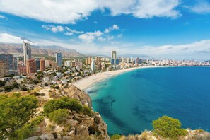 A coastal cityscape with a beach, high-rise buildings, and mountains in the background. - Benidorm Levante Beach Apartments (Benidorm)