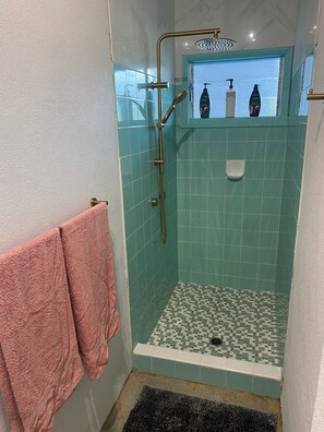 Een douche, handdoeken, zeep, toiletpapier