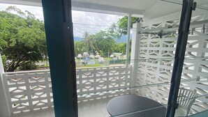 Ein Balkon mit Glastür, einem runden Tisch und einem weißen Stuhl.
