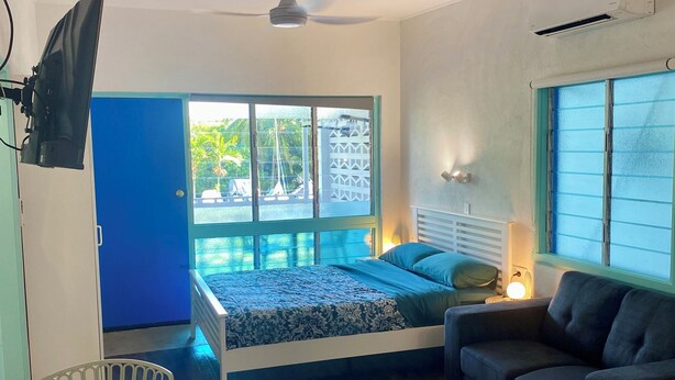 Ein Zimmer mit Bett, einer Couch, einem Tisch und einem Deckenventilator.