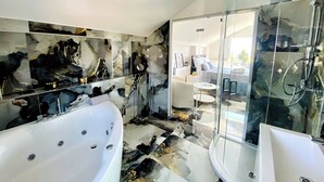 A modern bathroom with a large bathtub, a glass-enclosed shower, and a marble backsplash. - DRAMA @ Danza Del Mar / for Adults - View, Heated pool, Hot tub, Fast WI-FI (Vir)
