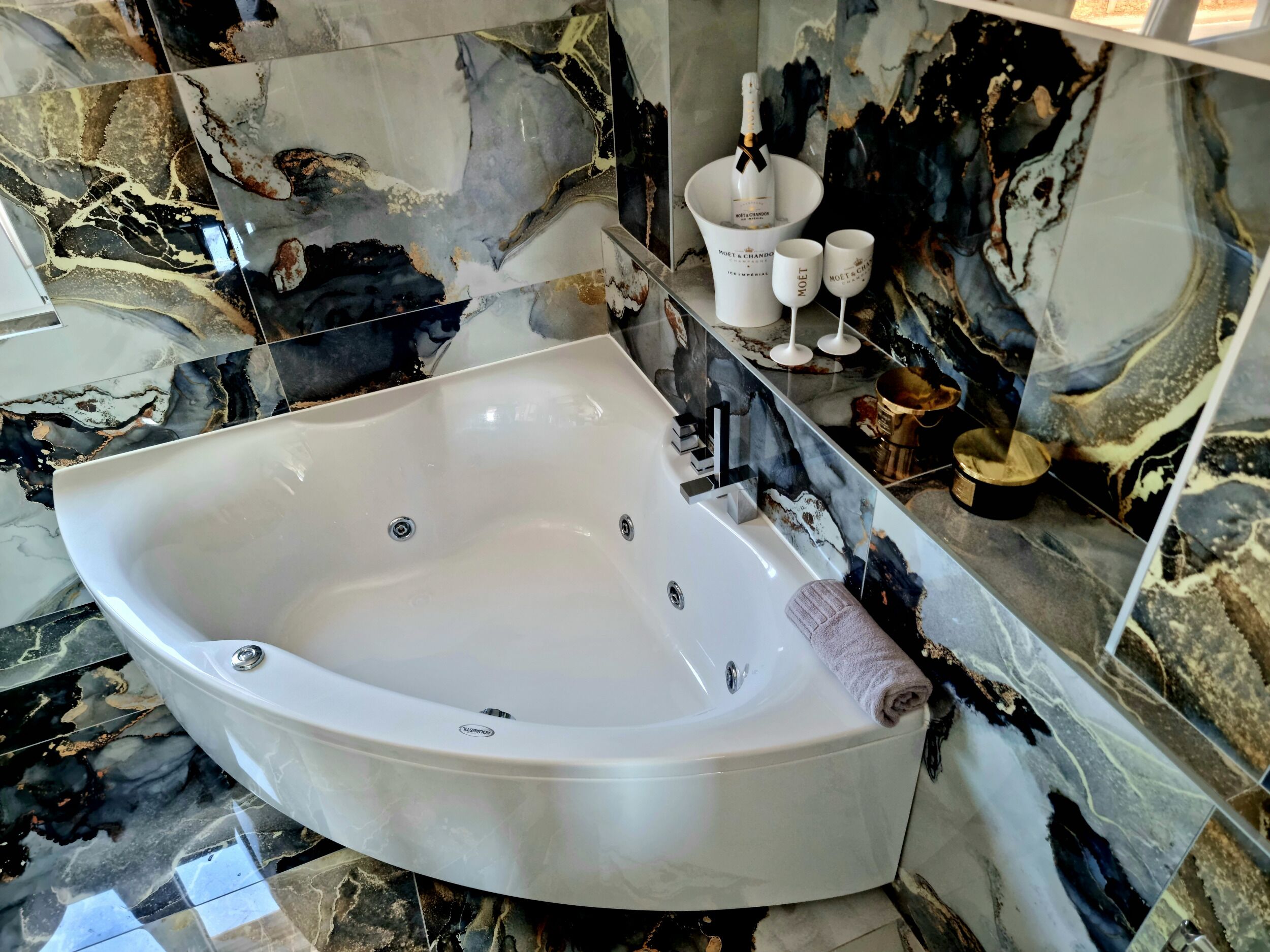 Un baño moderno con una bañera independiente, paredes de mármol y suelo de mármol.