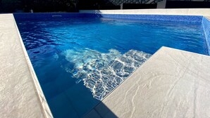 A swimming pool with clear blue water and a tiled edge. - DRAMA @ Danza Del Mar / for Adults - View, Heated pool, Hot tub, Fast WI-FI (Vir)