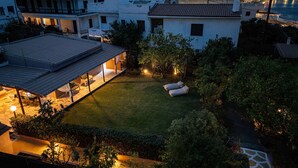 Een dakbalkon met een zitgedeelte, een pergola en een goed verlicht terras.